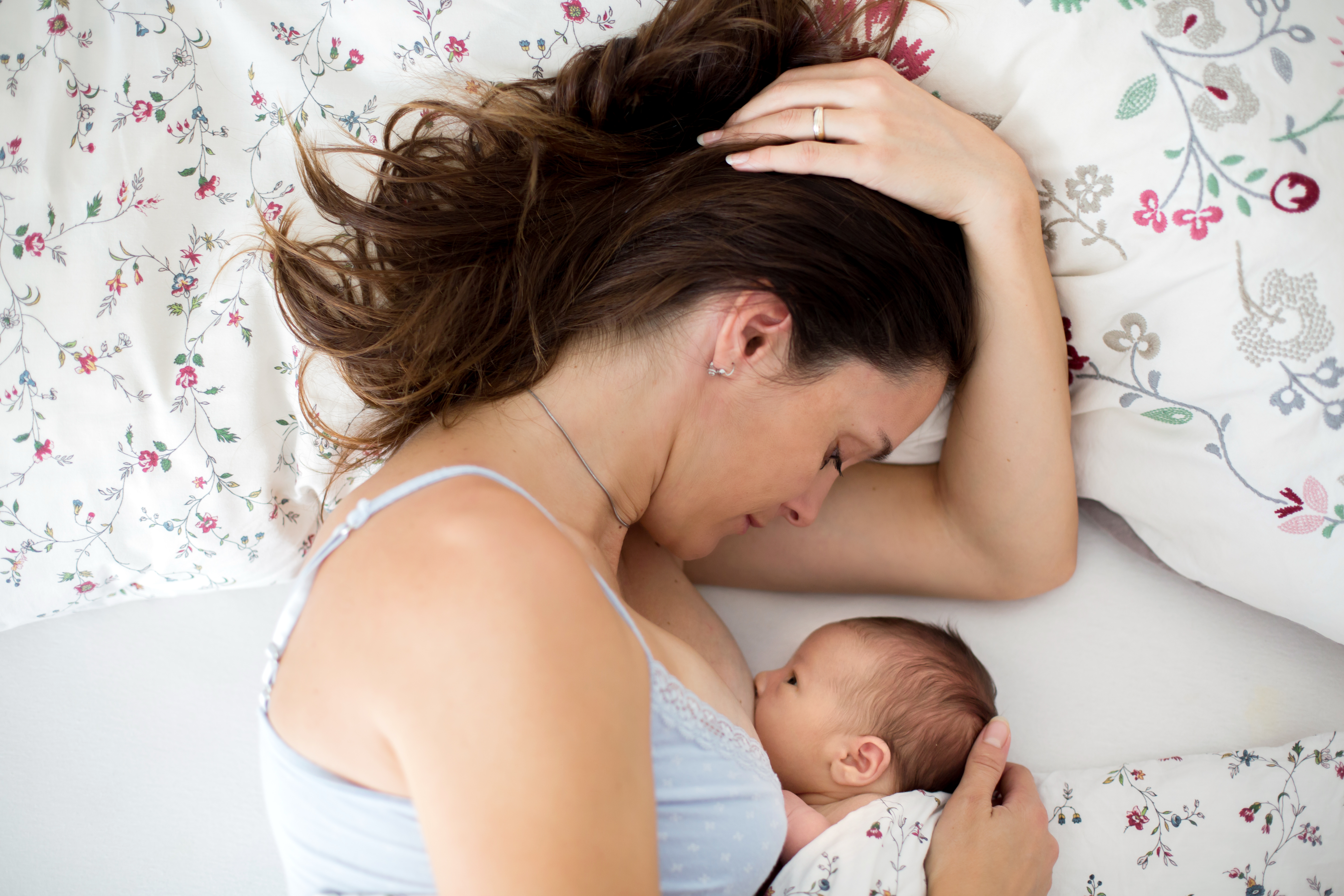 Mother breastfeeding baby in side lying position